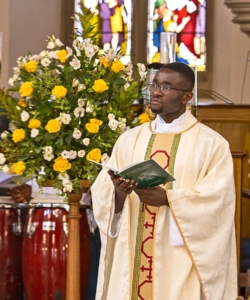 Fr Paschal beside flowers