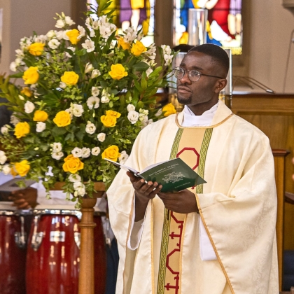 Fr Paschal beside flowers