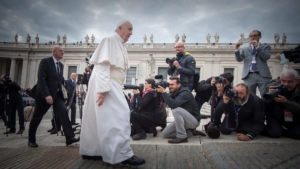Pope Francis walking in front of cameramen