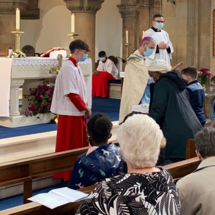 Bishop holds hand above parishioner