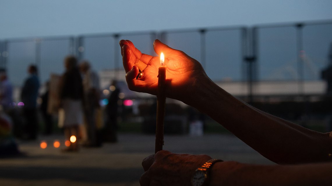 Hand shielding a candle flame